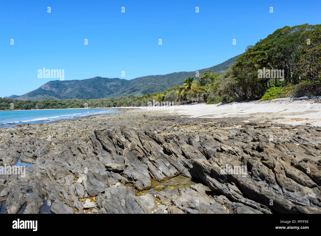 Picturesque coastline with hills, a beach and palmtrees near Port Douglas, Far North Queensland, FNQ, QLD, Australia Stock Photo