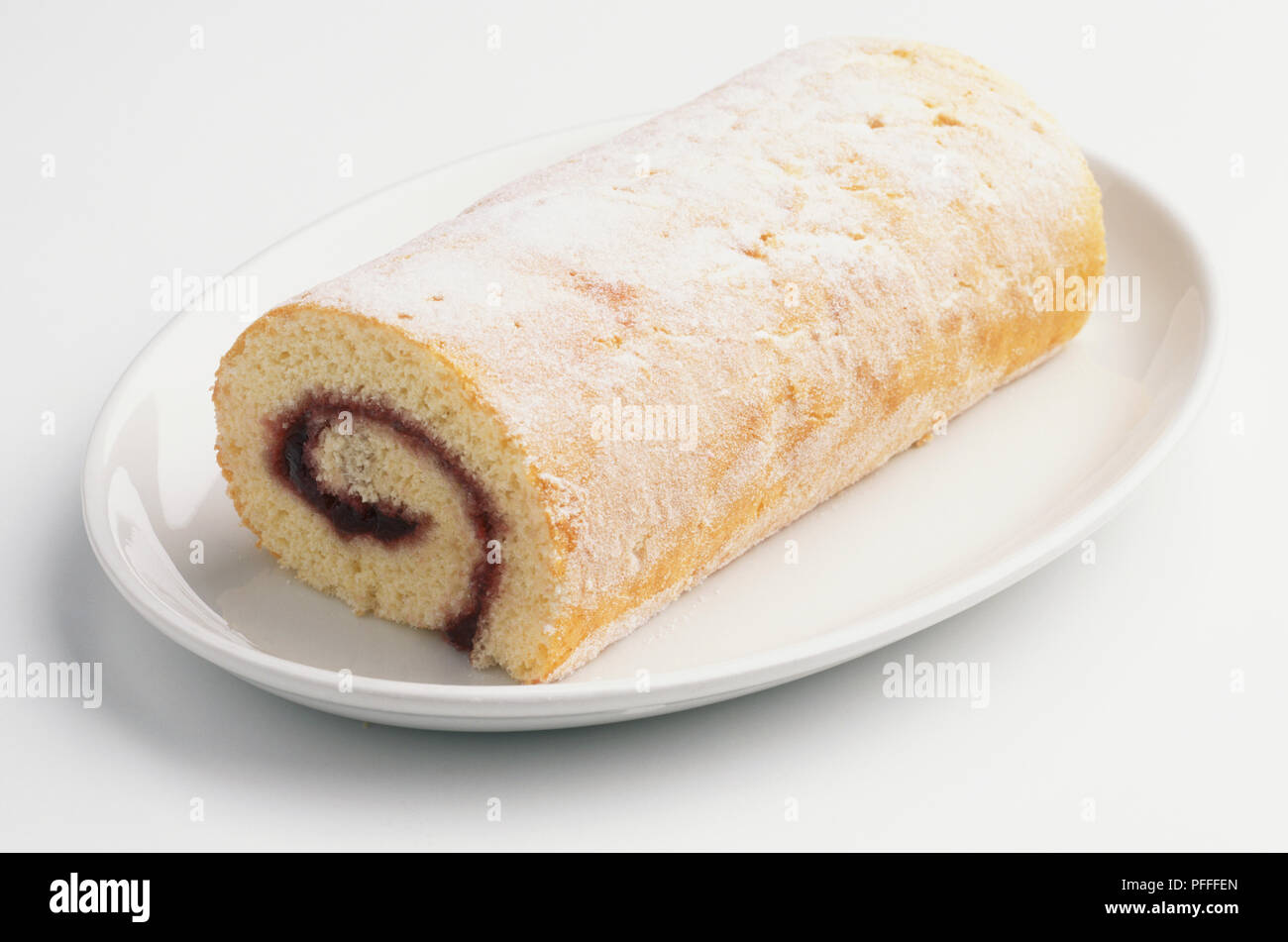 Swiss Roll, sponge cake spread with jelly and rolled up, served on