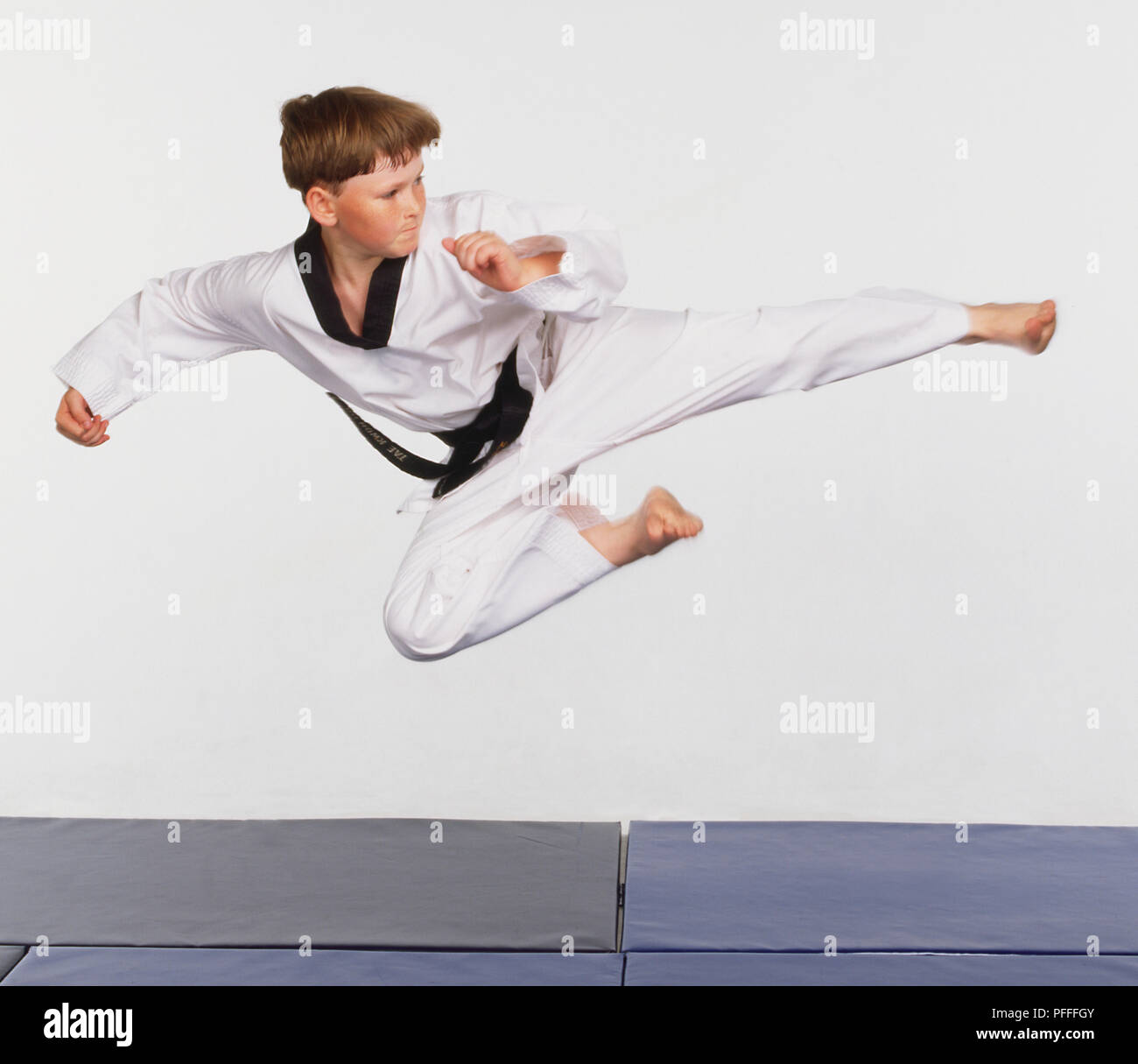 A boy in the midst of a flying roundhouse kick Stock Photo Alamy