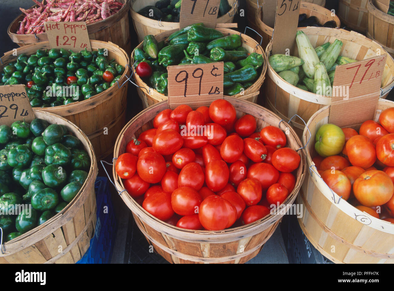 Canada, Ontario, Toronto, Little Italy, fresh vegetables, including tomatoes, green peppers and courgettes, on sale from wicker baskets, close up, high angle view. Stock Photo