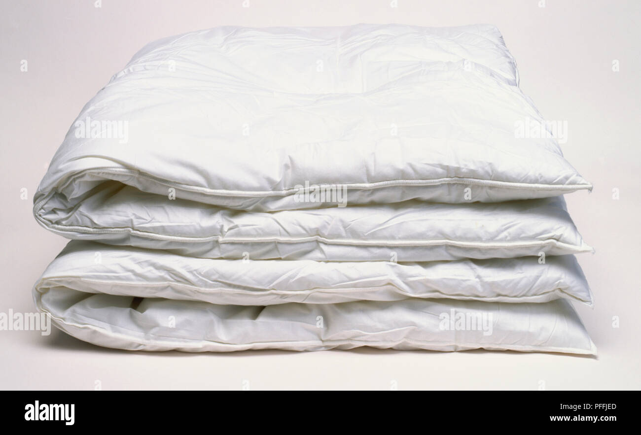 Two folded white anti-allergenic duvets, side view Stock Photo