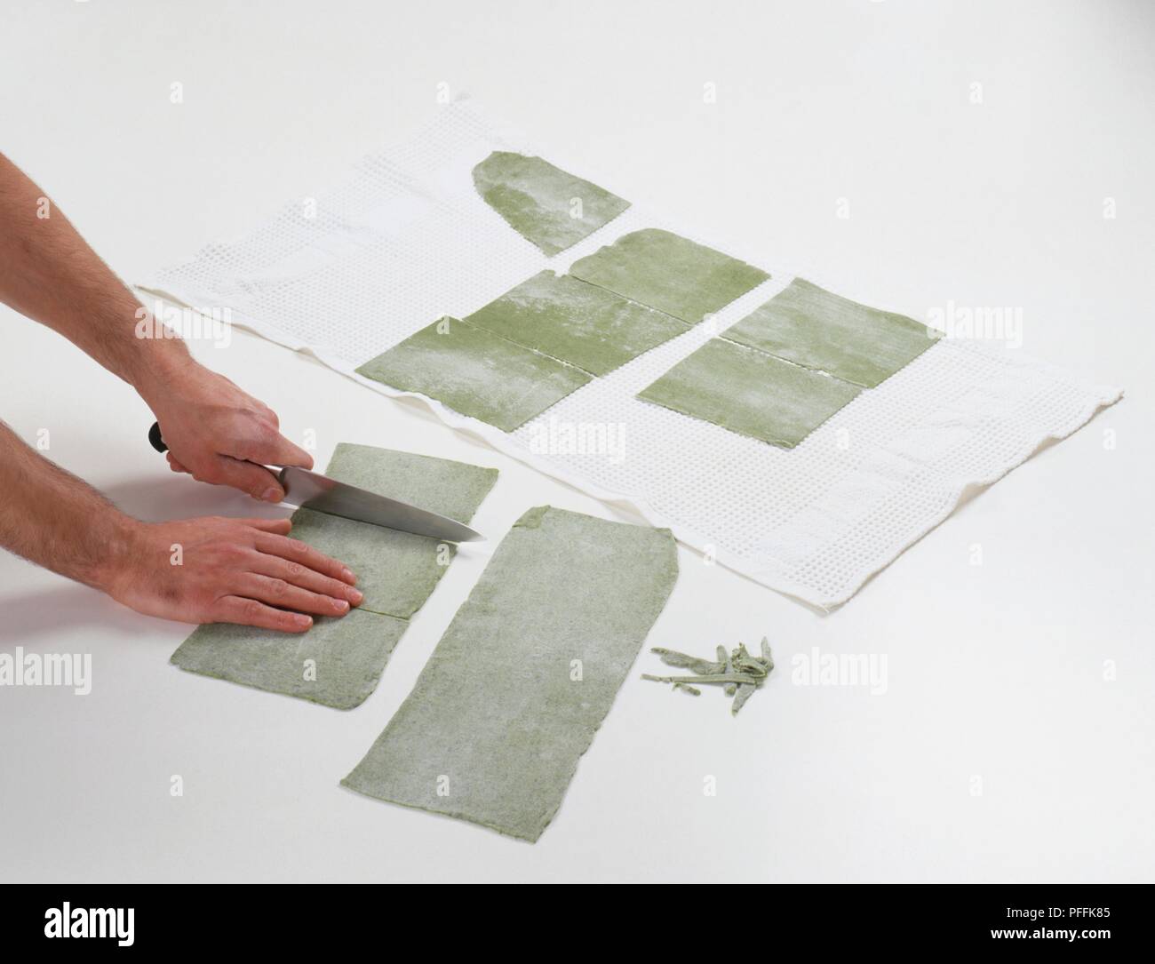 Cutting spinach pasta sheets into rectangles Stock Photo Alamy