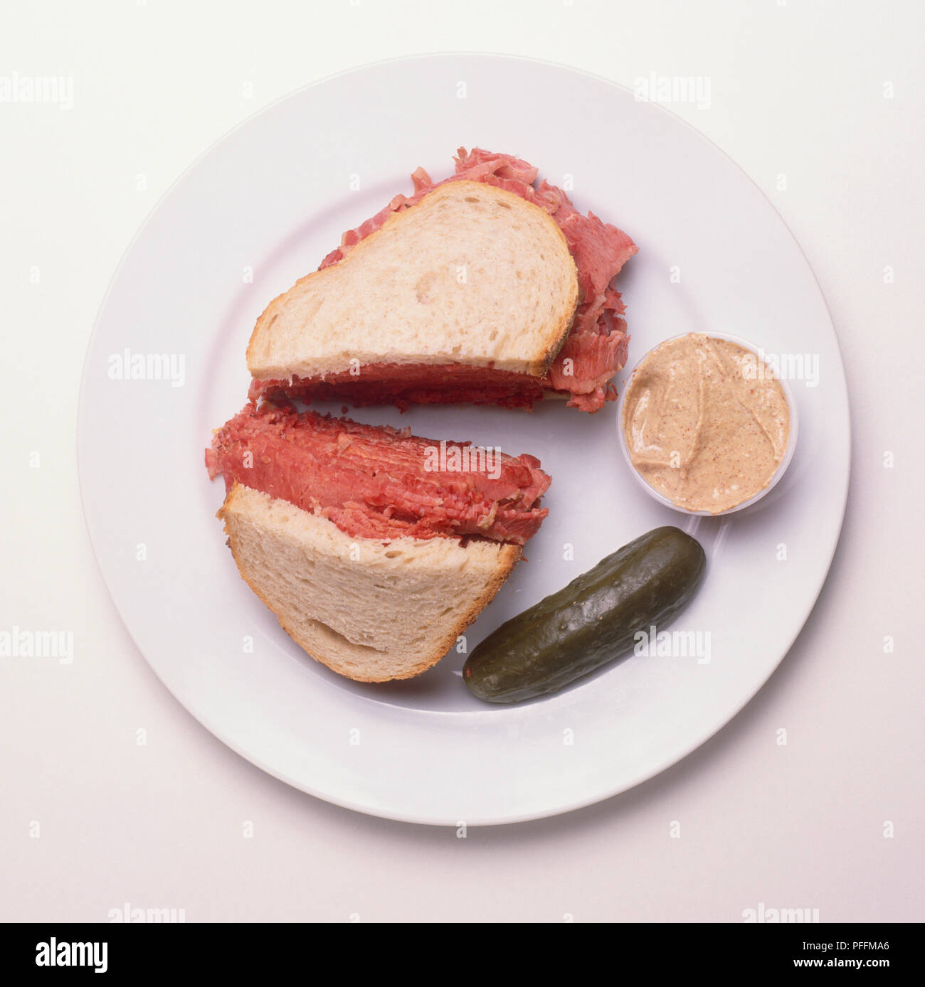 Rye bread sandwich stuffed with corned beef, served with mustard and