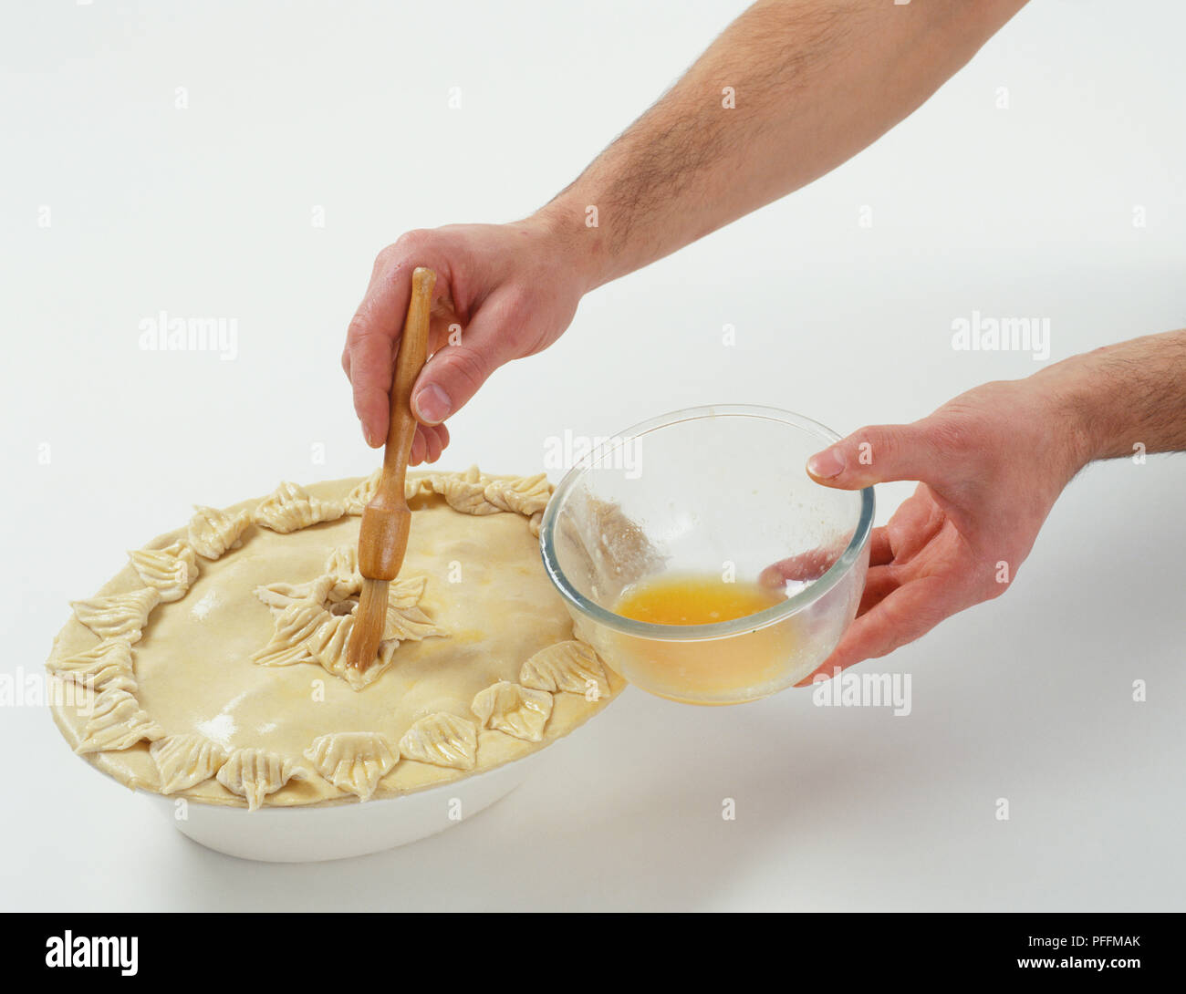 https://c8.alamy.com/comp/PFFMAK/glazing-the-pie-with-egg-wash-PFFMAK.jpg