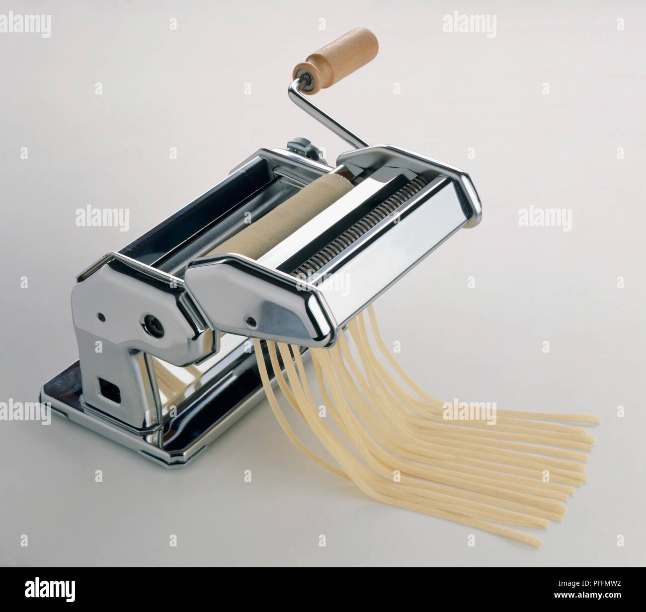 Using pasta machine to make fettuccine Stock Photo - Alamy