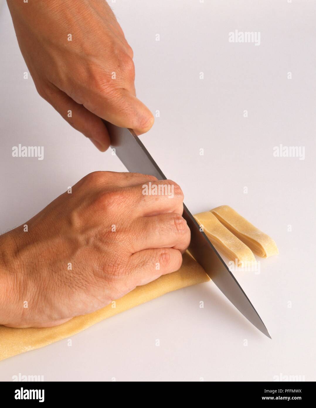 Using kitchen knife to cut pasta dough Stock Photo Alamy