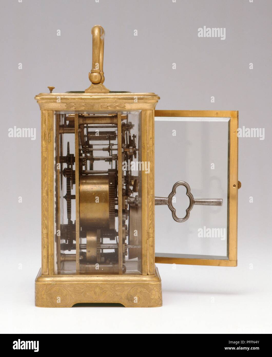 Carriage clock showing inside mechanism and key for winding up, side view Stock Photo