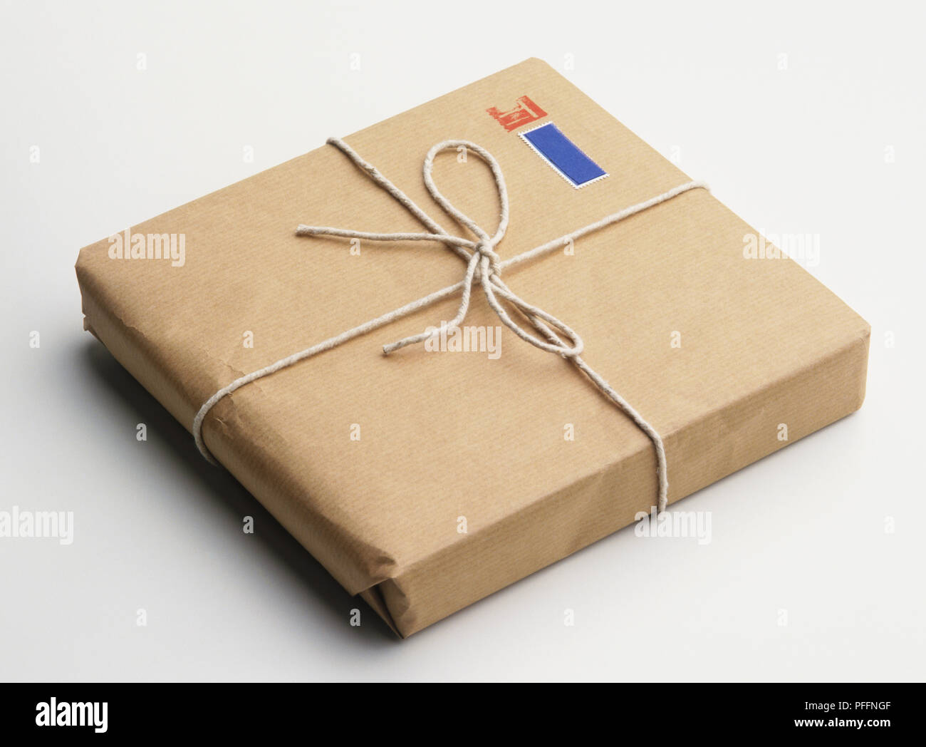 Flat parcel wrapped up in brown paper and string Stock Photo - Alamy