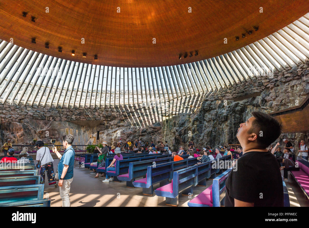 Helsinki Temppeliaukio Church, a tourist inside the Temppeliaukion Kirkko or 'Rock Church' in central Helsinki gazes at its huge copper roof, Finland. Stock Photo