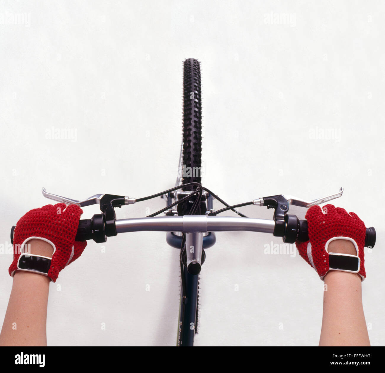 Hands wearing cycling gloves holding the handle bars on a bike, close-up, view from above Stock Photo
