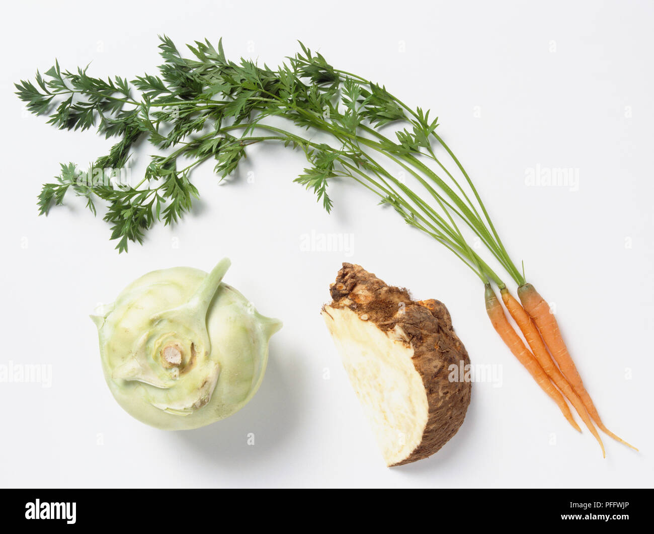 Kohlrabi, slice of celeriac and three carrots with stems still attached, view from above Stock Photo
