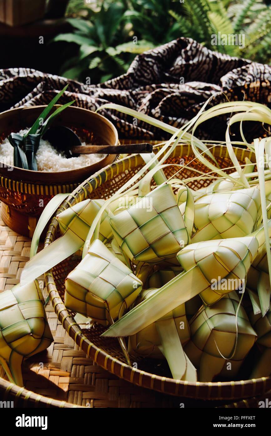 Ketupat, the traditional diamond-shaped rice cake in casing of woven coconut leaf; highly popular during Eid celebrations. Stock Photo