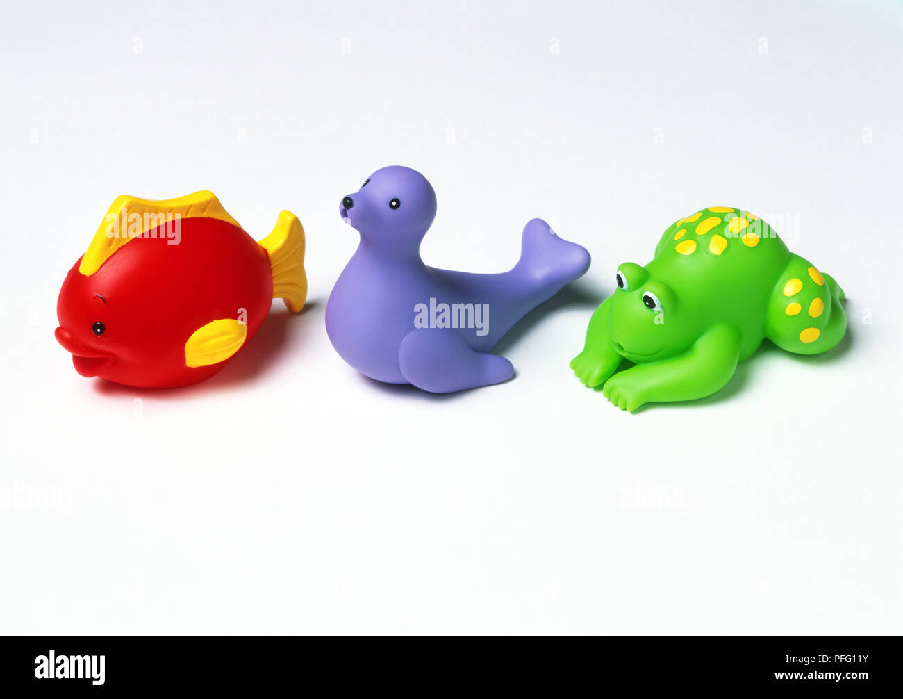 Plastic red toy fish, blue seal and green frog Stock Photo - Alamy