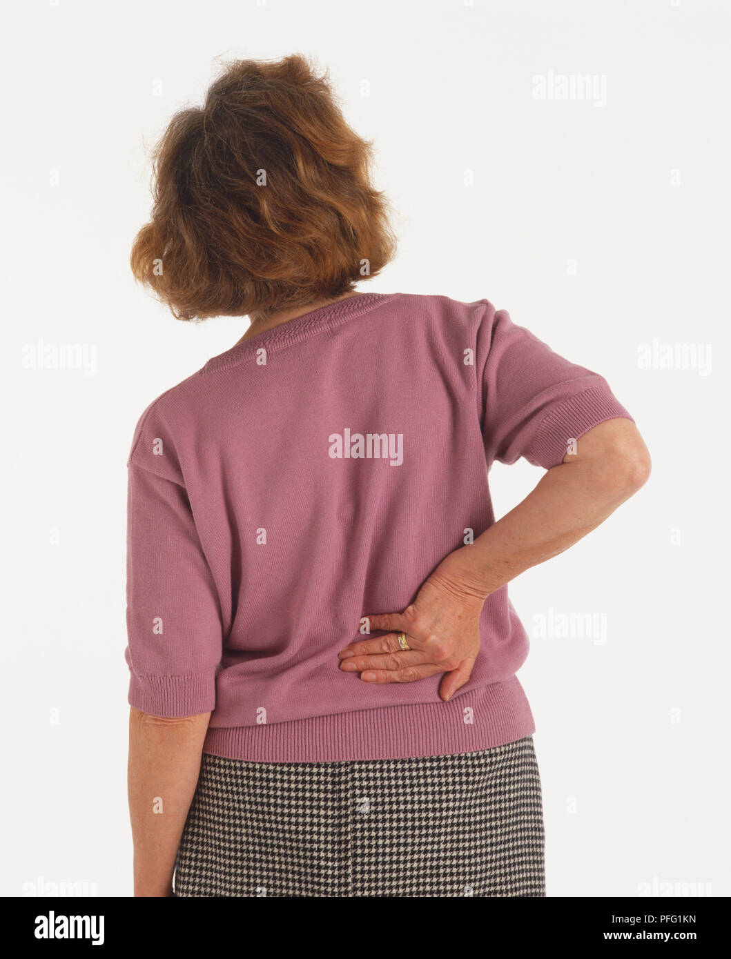 Rear view of mature woman touching her back. Stock Photo