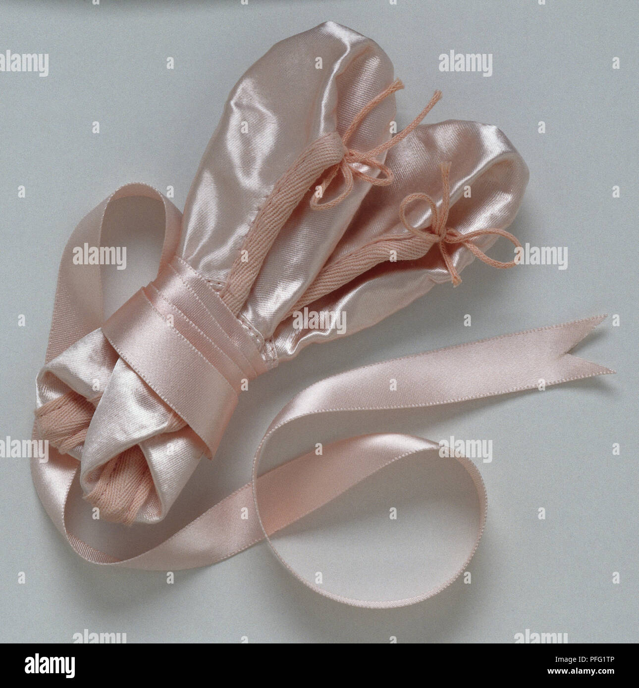 Pale pink ballet shoes with satin ribbons wrapped around them Stock
