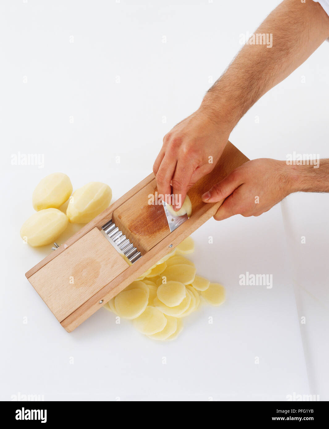 Person slicing potatoes using a mandoline Stock Photo Alamy