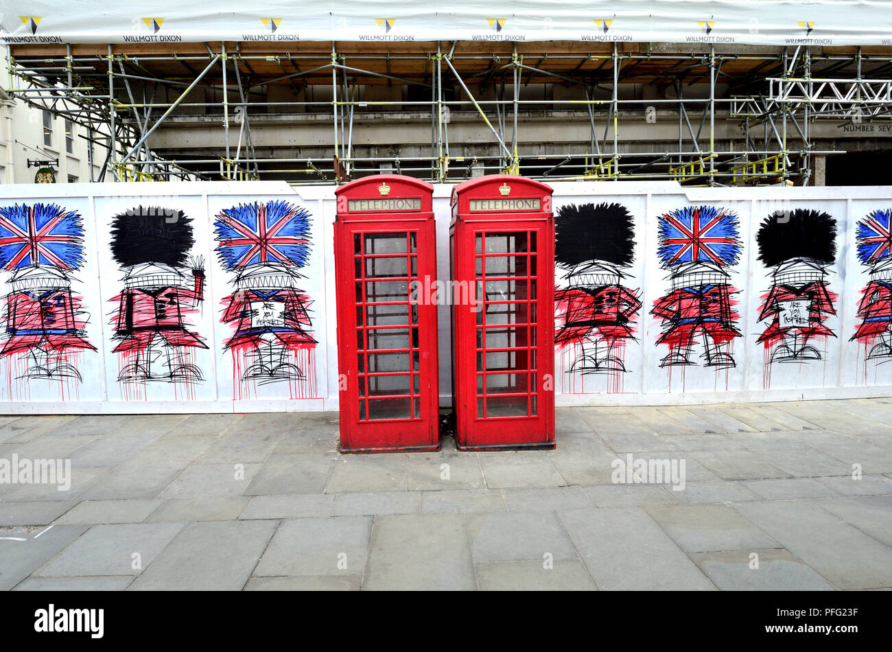 Red telephone boxes and graffiti guardsmen (by Nathan Bowen) in St Martin's Place, London, England, UK. Stock Photo