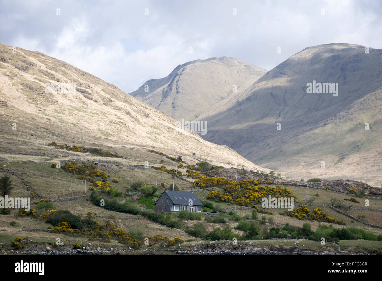 a lonely house in the irish country side surrounded by a mountain range Stock Photo
