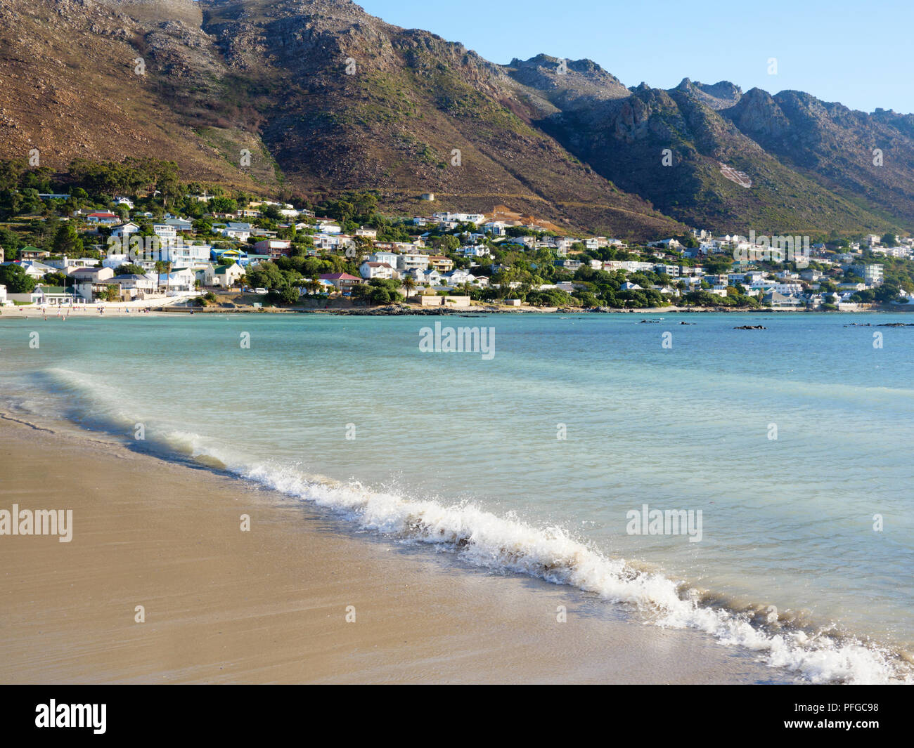 Bikini beach Gordon's Bay, with Gordon's Bay town and Hottentots Holland Mountains behind Stock Photo