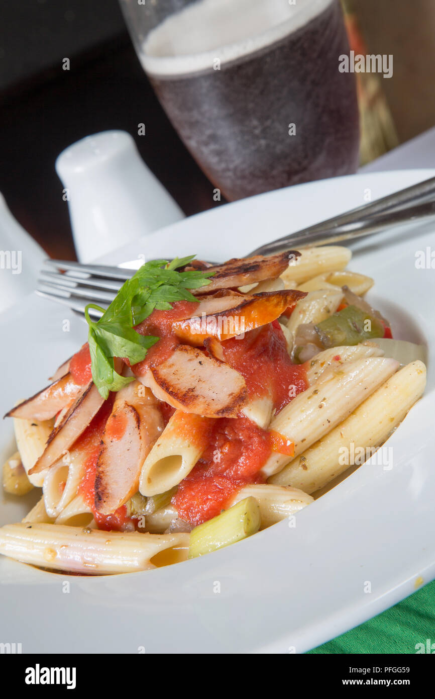 Italian style dish of penne pasta and vegetables with sliced fried sausage and Passata sauce