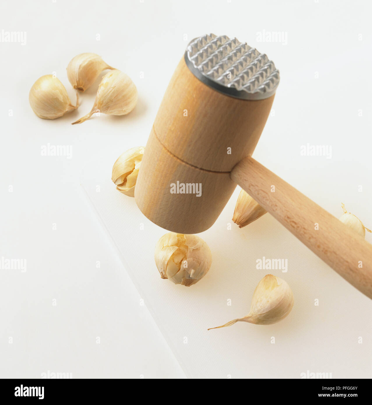 Using a wooden mallet to crushing garlic cloves, high angle view Stock