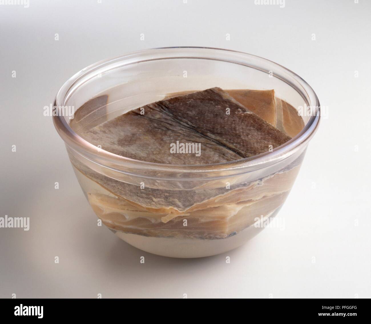 Rehydrating dried cod in bowl of cold water Stock Photo - Alamy