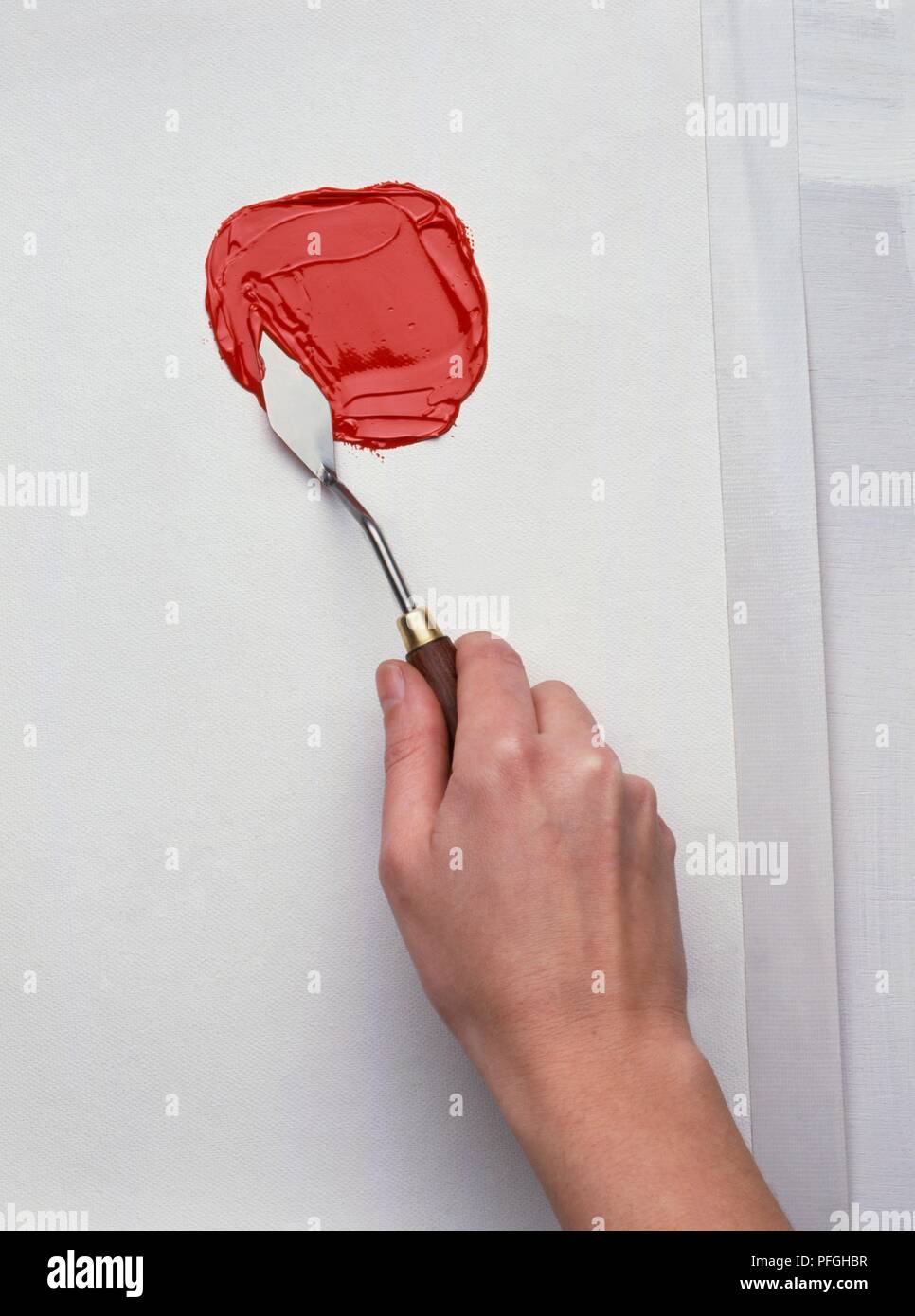 https://c8.alamy.com/comp/PFGHBR/applying-thick-layer-of-red-paint-with-painting-knife-PFGHBR.jpg