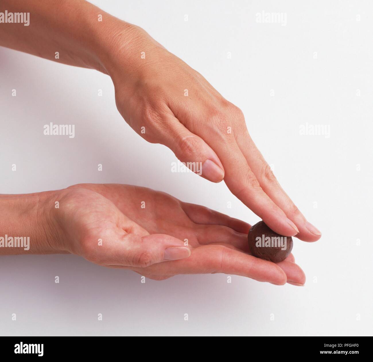 Using fingertips to roll chocolate truffle ingredients into ball Stock ...