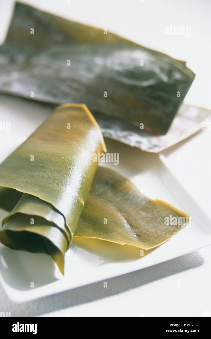 Kombu (kelp), rolled up seaweed sheets on plate, closeup Stock Photo