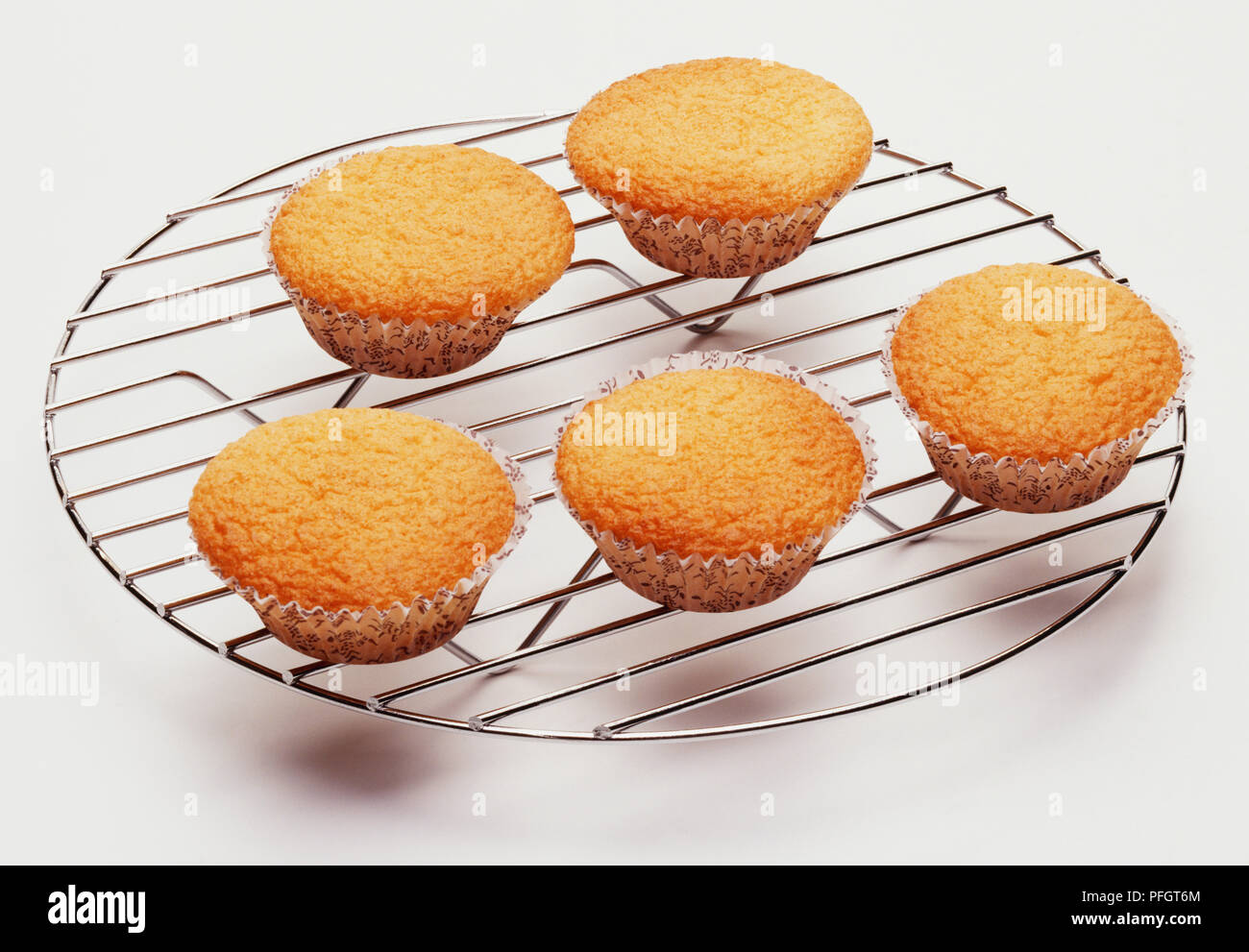 A wire cooling rack holding five fairy cakes Stock Photo Alamy