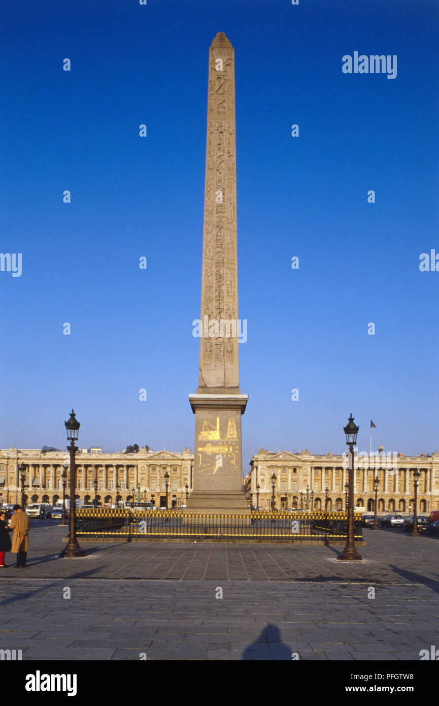 France, Paris, Obelisk of Luxor at the Place de la Concorde, Egyptian obelisk towering over building covered in gilded hieroglyphic engravings. Stock Photo