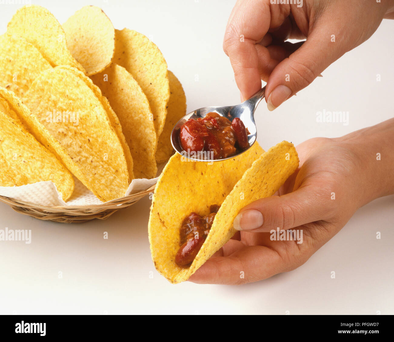 Using a spoon to fill a taco shell, close up Stock Photo Alamy