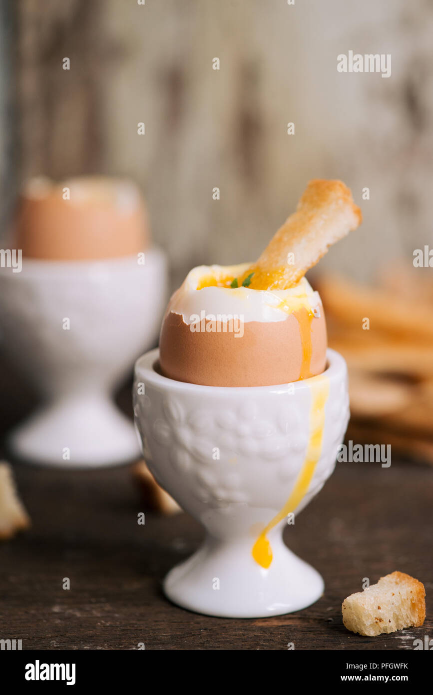 The yolk flows from boiled egg on toast Stock Photo Alamy