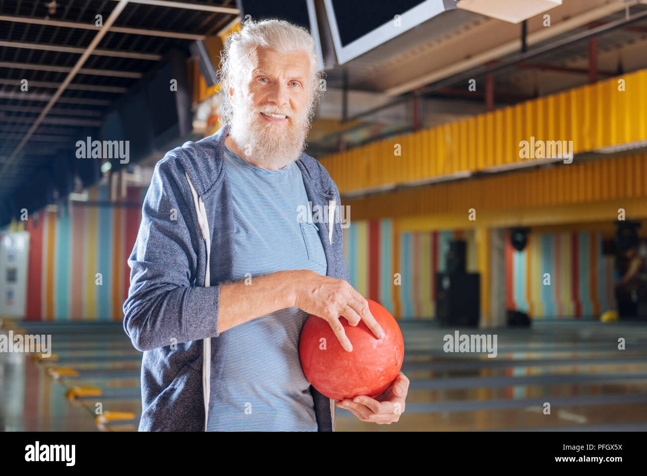 Pleasant senior man smiling in the bowling club Stock Photo