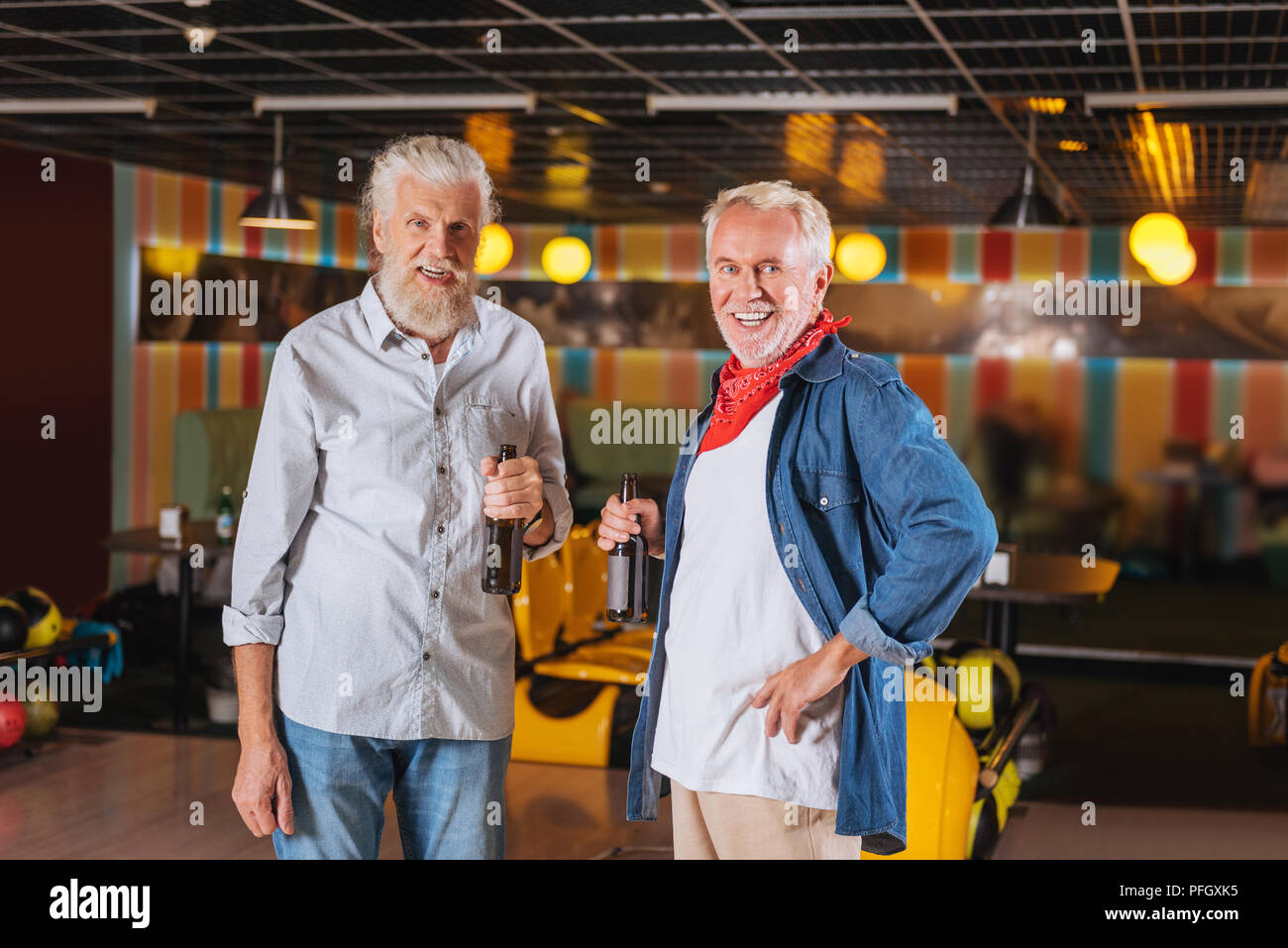 Positive smiling aged men standing together in the bowling club Stock Photo