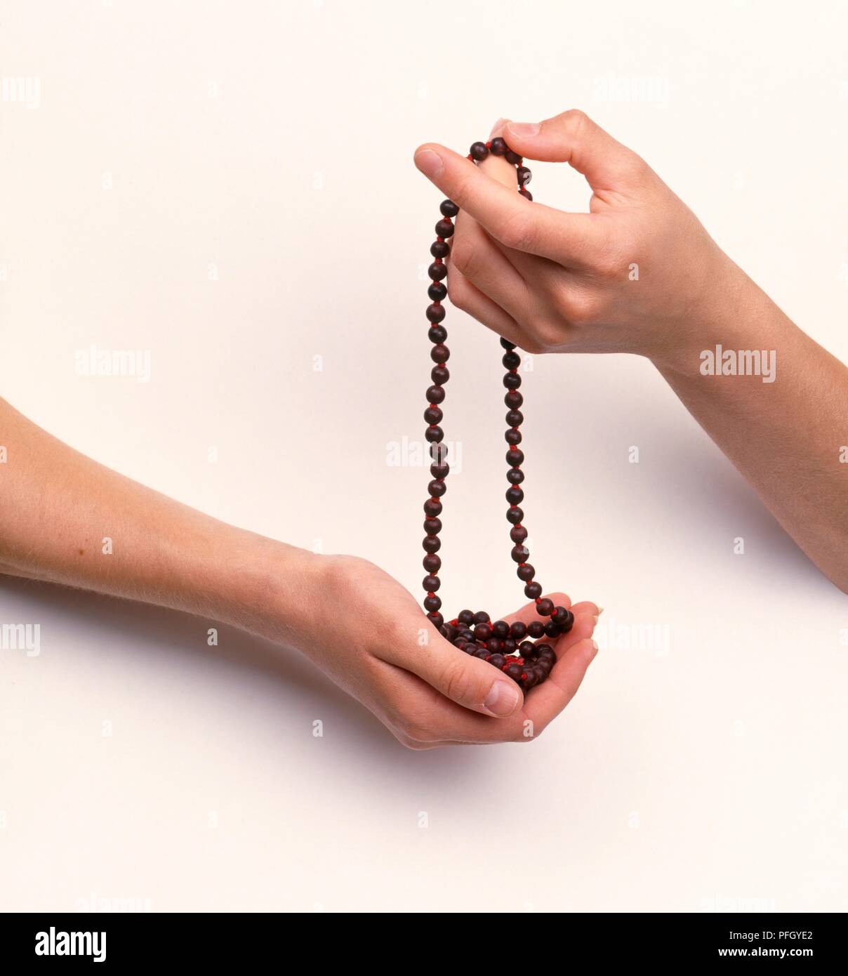 Hands holding set of prayer beads Stock Photo - Alamy