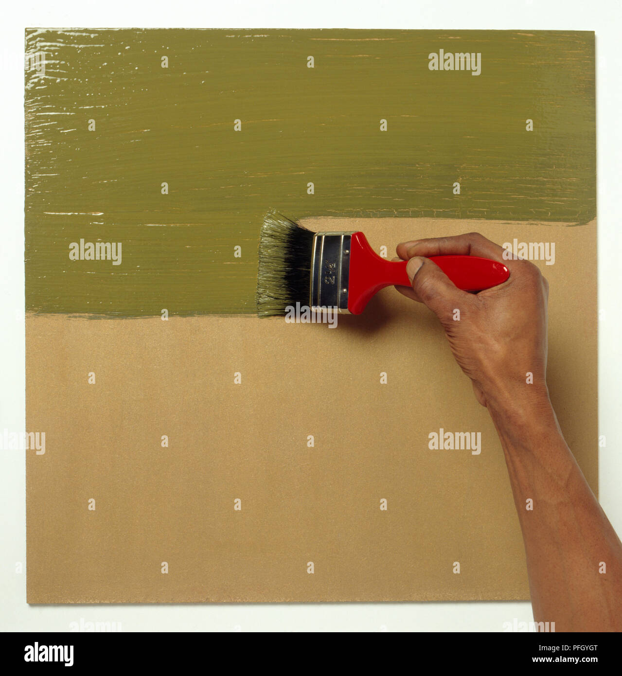 Applying green crackle glaze paint to wooden board using paintbrush