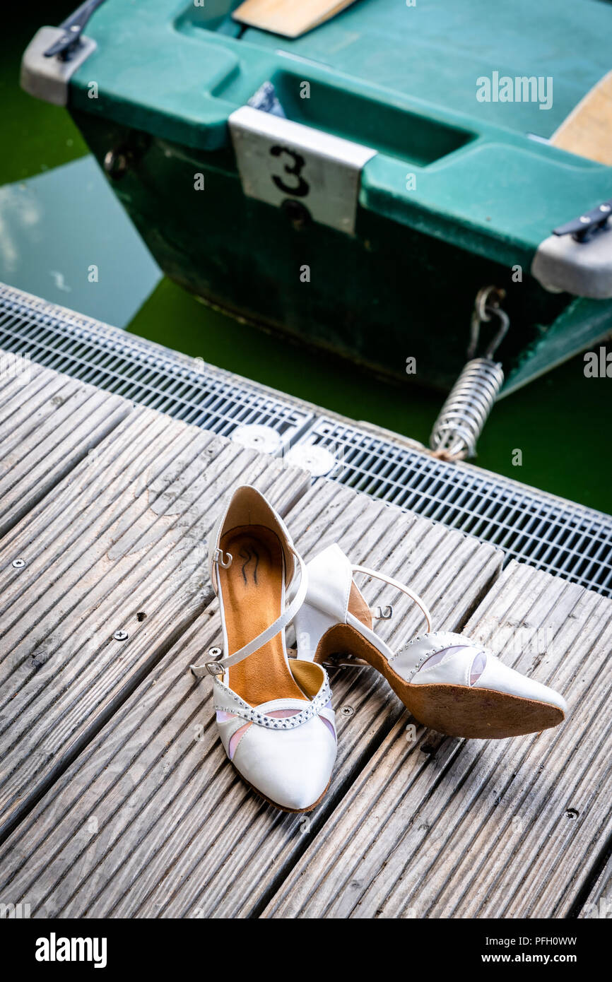 The shoes of the bride lie on the boat dock Stock Photo