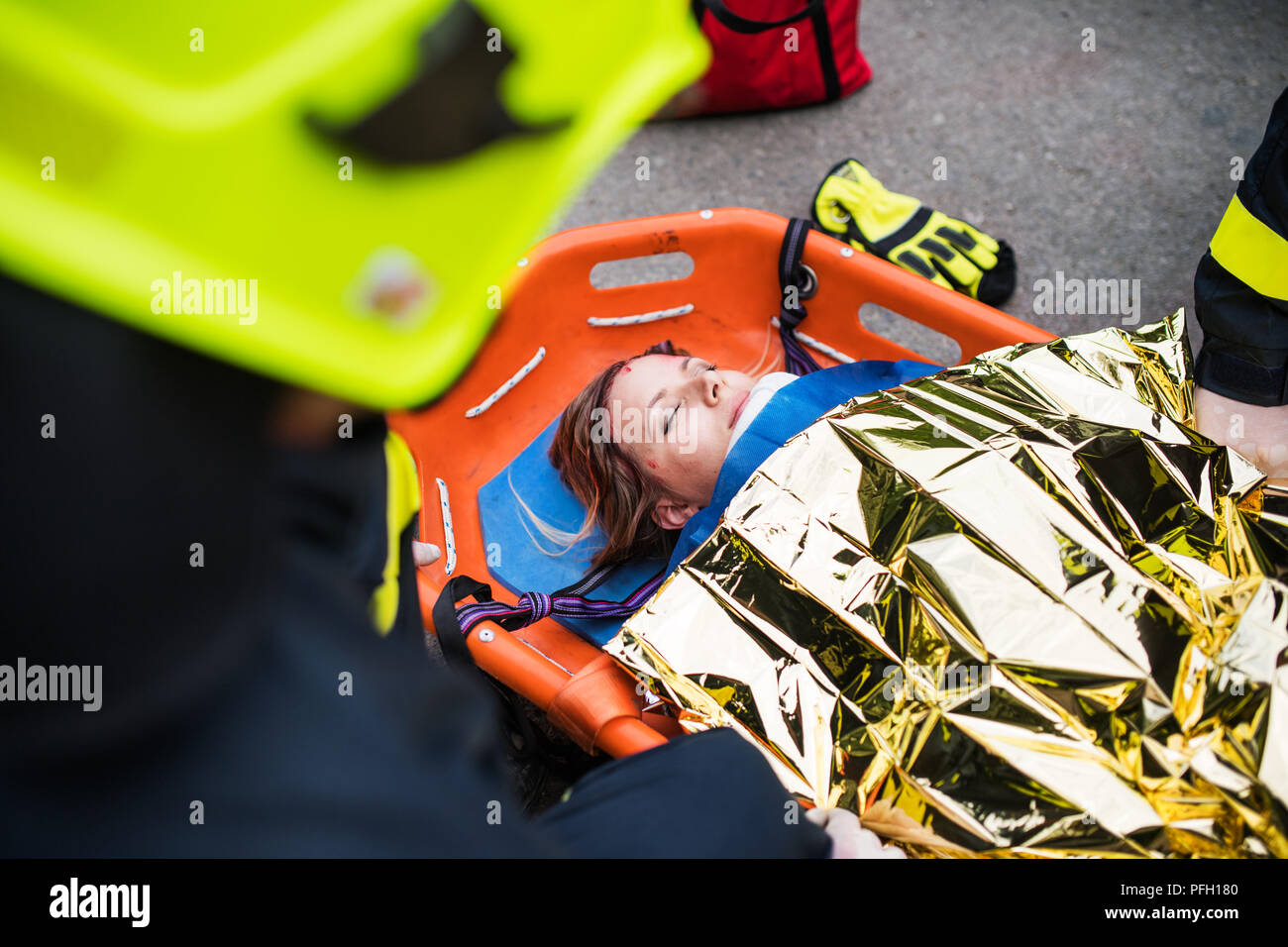 A young injured woman in a plastic stretcher after a car accident