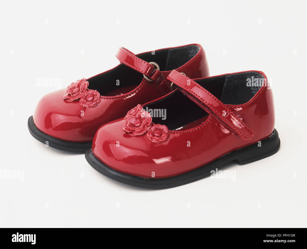Child's red patent leather shoes with strap and flower detail Stock Photo Alamy