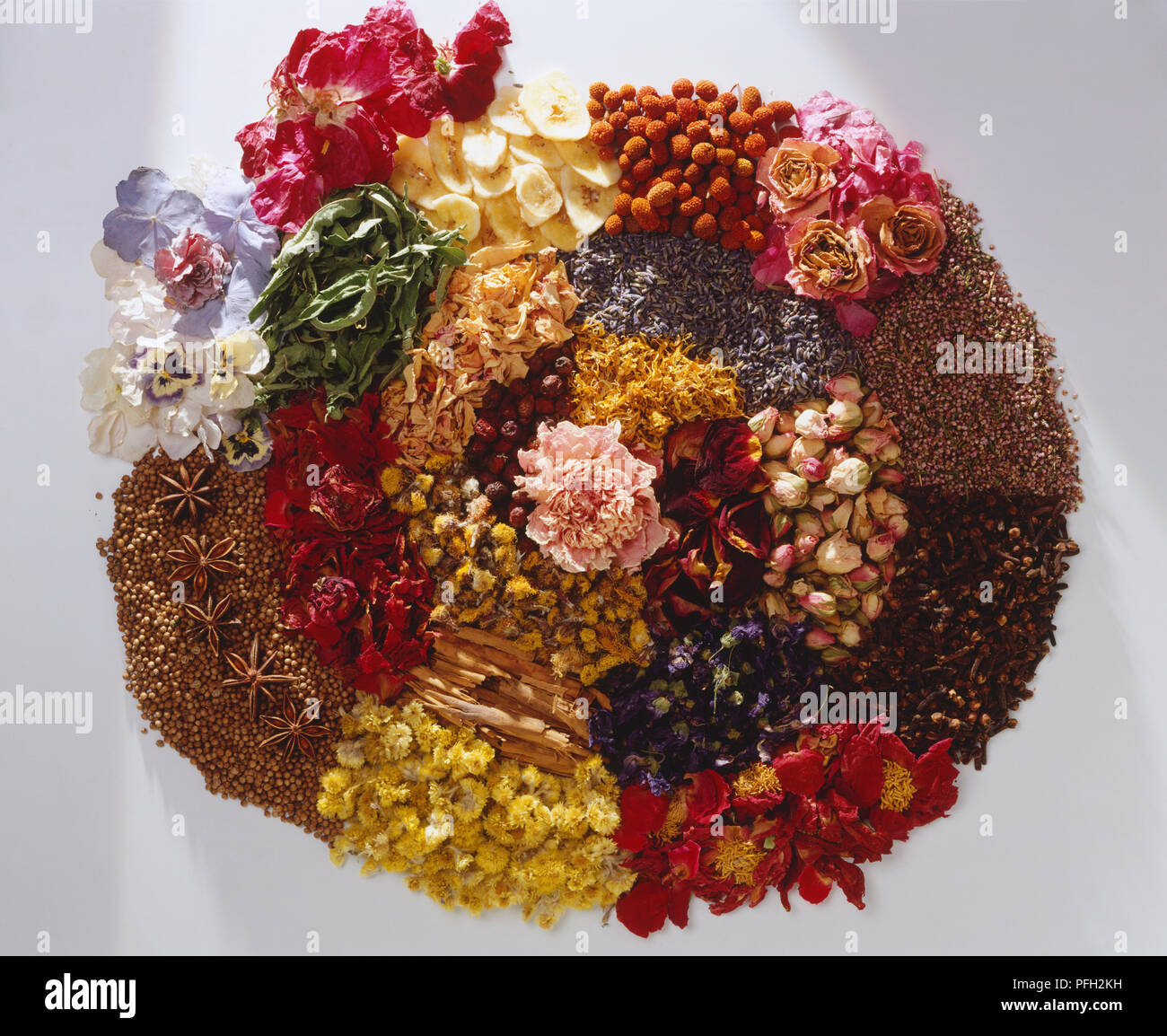 Above view of a variety of dried flowers, petals, herbs and spices including roses, cinnamon, lavender. Stock Photo