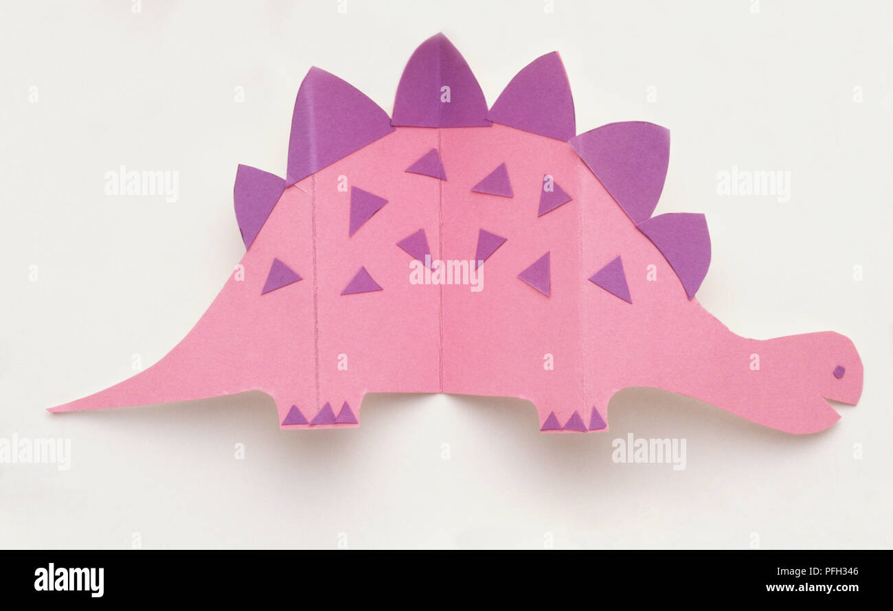 Pink paper dinosaur with purple spikes, side view Stock Photo