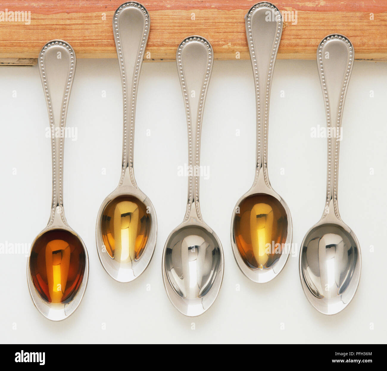 Liquid flavourings in five teaspoons, including dark rum, brandy
