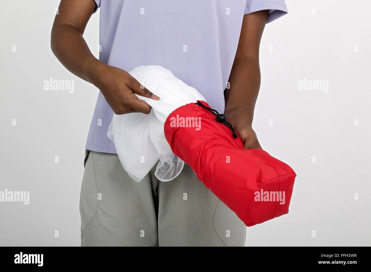 Young woman taking mosquito net out of bag Stock Photo