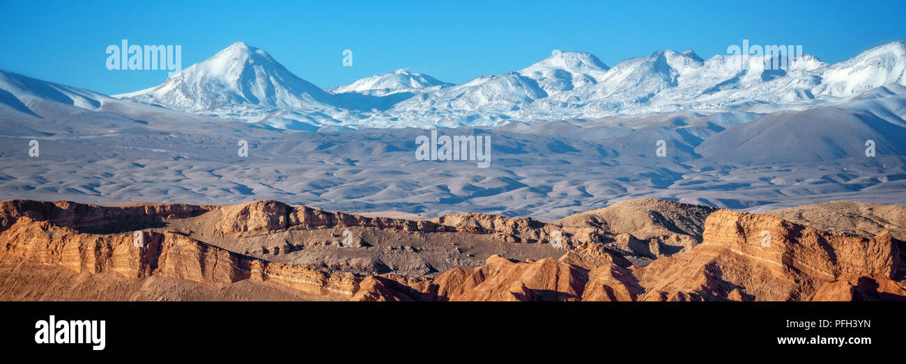 Panorama of Moon Valley in Atacama desert, snowy Andes mountain range in the background, Chile Stock Photo