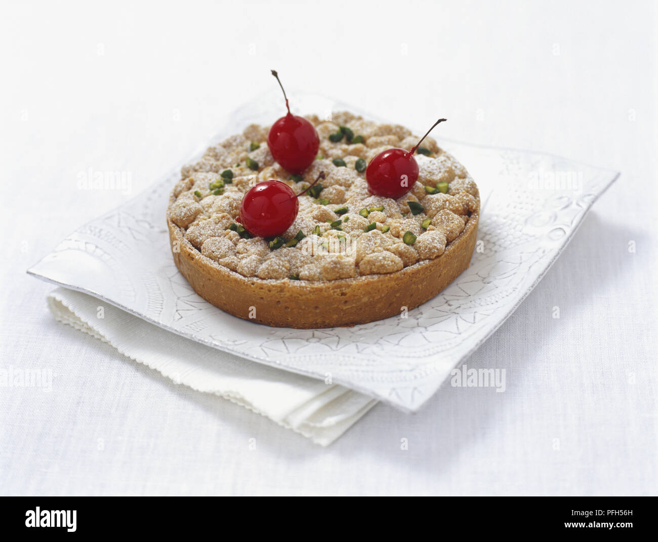 Cherry and pistachio tart on white napkin Stock Photo