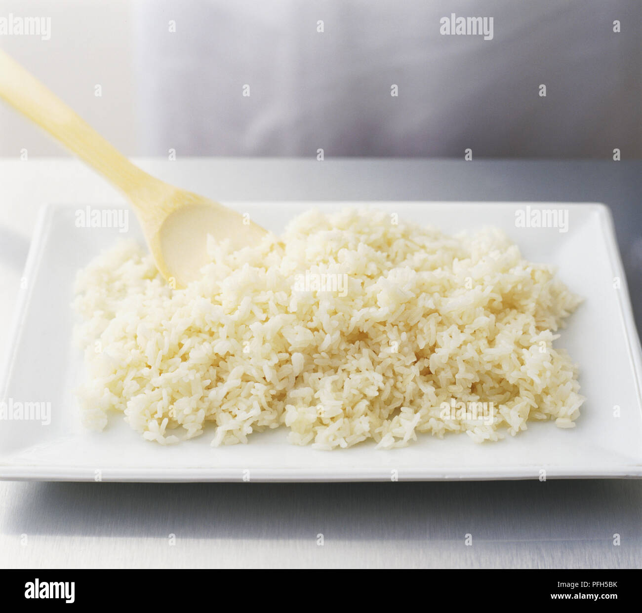 White rice and wooden spoon on rectangular plate, high angle view Stock ...