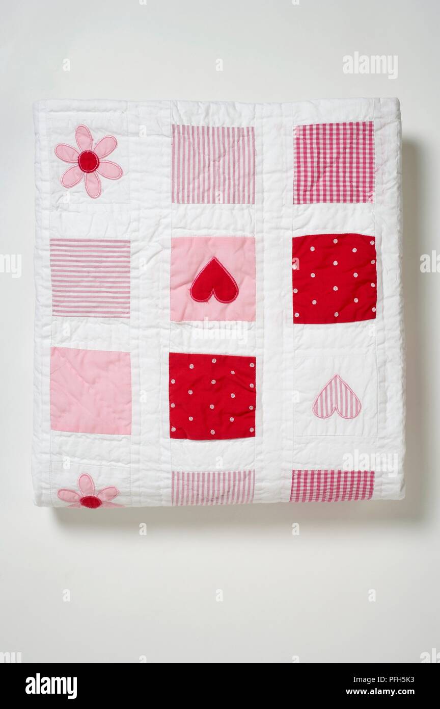 Red, white and pink patchwork baby blanket, close-up Stock Photo