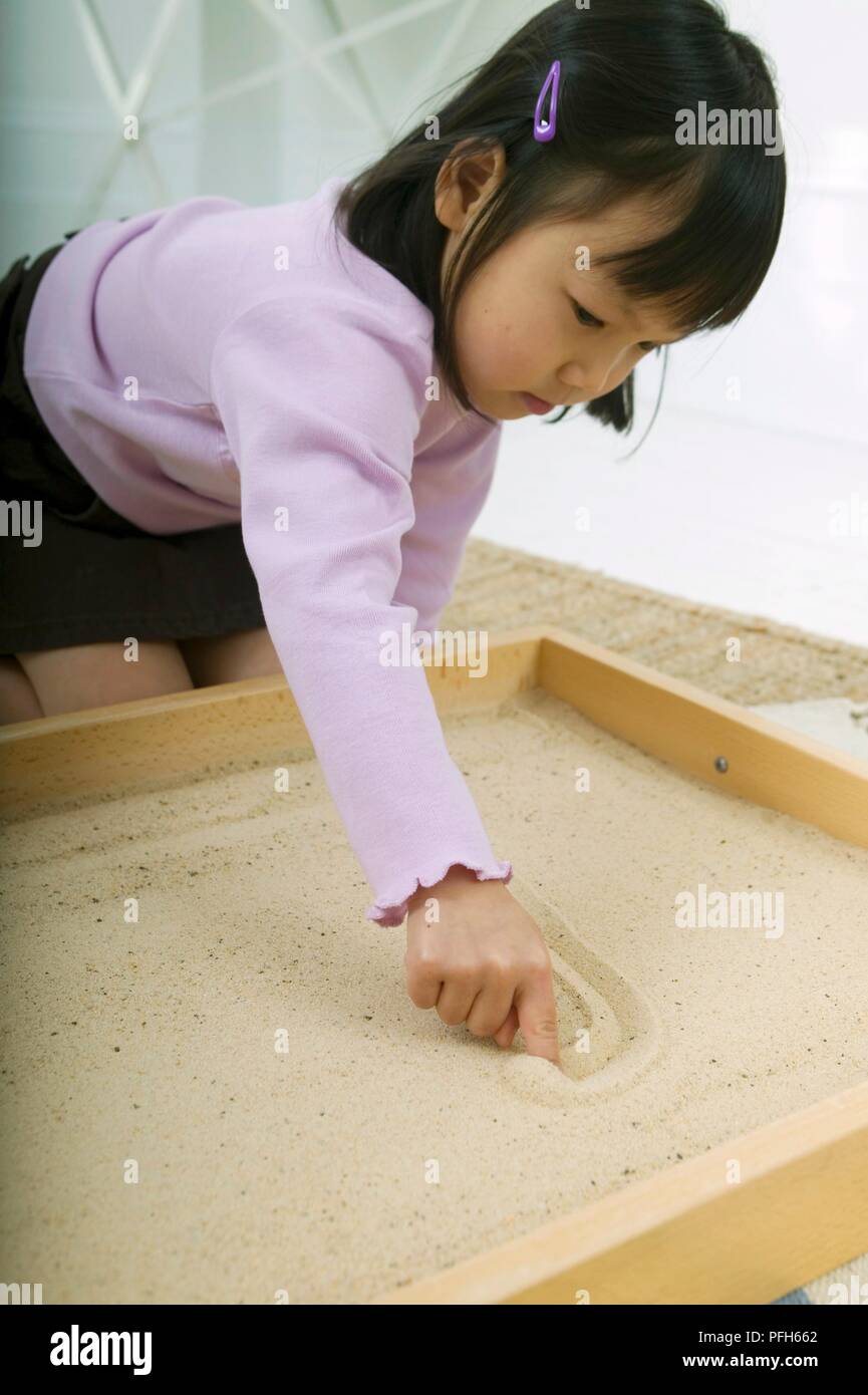 Girl kneeling in the sand hi-res stock photography and images - Alamy