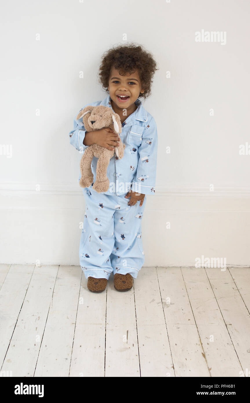 Boy in blue pyjamas holding toy, smiling Stock Photo Alamy